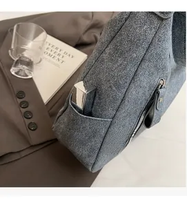 Close-up of dark grey textured tote bag featuring a functional side pocket and metal zipper