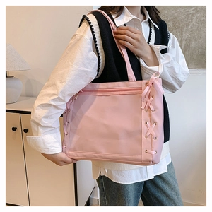 Detailed view of pink nylon tote bag featuring a clear PVC window and side ribbon bows