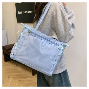 Sky blue ita bag with transparent PVC window and side ribbon bows in detail view