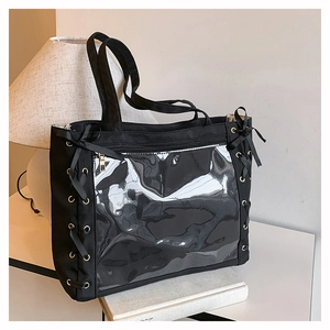 Detail view of black canvas ita bag featuring clear window and side ribbon bow accents