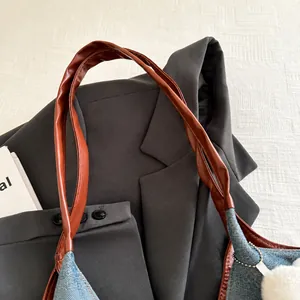 Détail de la poignée en cuir PU marron et du denim bleu avec garniture en peluche blanche