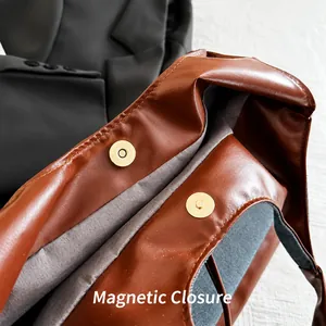 Détail de la fermeture magnétique dorée sur le sac cabas marron en denim patchwork