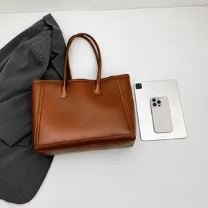 Vista piatta di una grande borsa tote marrone con tablet per stile professionale