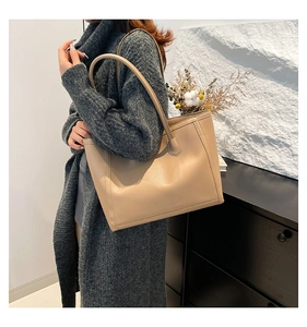 Dettaglio della borsa tote beige minimalista in ecopelle con grana fine sulla pelle