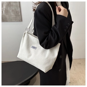 Dettaglio della borsa tote in velluto a coste bianco con trama a costine ed etichetta