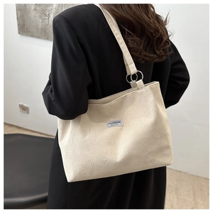 Dettaglio della borsa tote in velluto a coste beige con etichetta Fashion Instinct