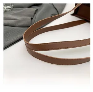 Close-up of brown litchi pattern leather strap with neat stitching on leopard tote bag
