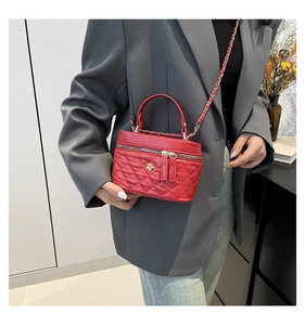 Dettaglio borsa trapuntata rossa con emblema a fiore dorato e catena su modella