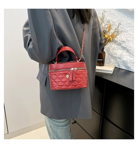 Dettaglio della mini borsa a scatola trapuntata rossa con fiore d'oro e catena