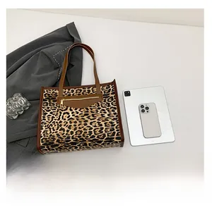 Detail view of leopard print tote bag featuring a leather zipper pocket and large capacity