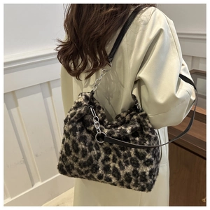 Details einer Schultertasche aus Leoparden-Kunstfell mit silberner Metallkette am Model