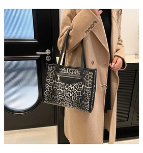 Leopard print tote bag worn with a camel coat showing large capacity and zipper detail