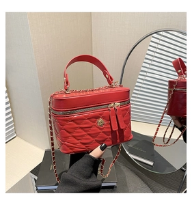 Macro di borsa rossa trapuntata con ciondolo floreale dorato e tracolla a catena