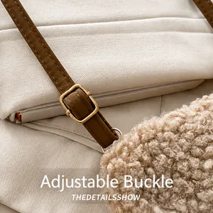 Detail of adjustable brown leather shoulder strap with a gold metal buckle on a plush bag