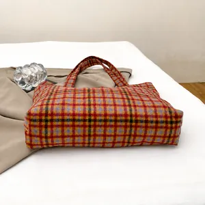 Detailed view of the wear-resistant wide base on this plaid wool tote bag