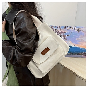 Dettaglio della borsa tote in tela grande con tasca frontale ed etichetta decorativa