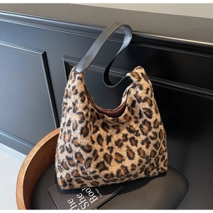 Detailed close-up showing the soft leopard print faux fur texture and black leather strap