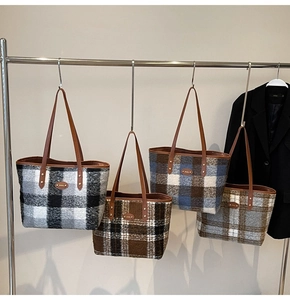 Détail de cabas en laine aux divers motifs à carreaux avec anses en cuir et rivets