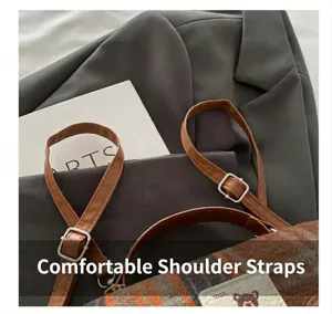 Détail de la bandoulière réglable en cuir marron avec boucle sur le sac à carreaux