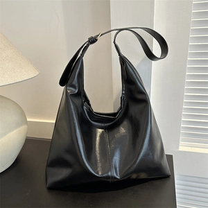 Grote zwarte PU-lederen tote bag met verstelbare schouderband in minimalistische stijl