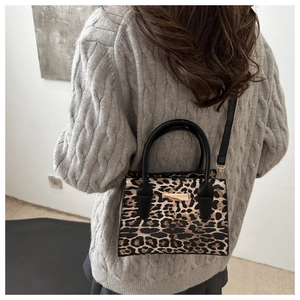 Détail du petit sac carré à imprimé léopard avec garniture dorée et bandoulière noire