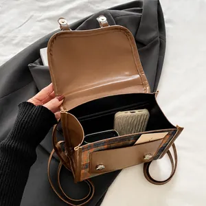 Detail view of the open plaid backpack interior showing storage space for a smartphone