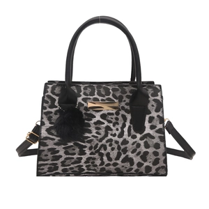 Chic leopard print handbag with black handles and a cute pom-pom charm on white background