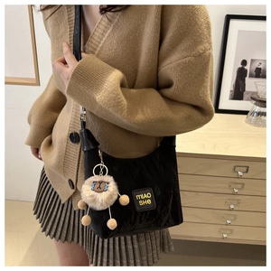 Detail shot of black nylon shoulder bag with Miao She logo and cute sheep charm pendant