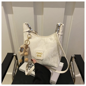 Detail of white crescent bag with marble texture, alpaca charm and logo on front