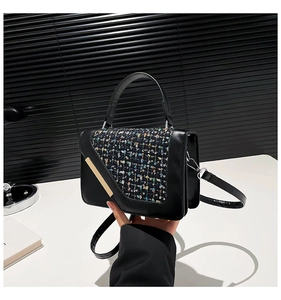 Détail du sac à main en cuir noir et tweed avec des accents métalliques dorés élégants