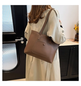 Gros plan d'un grand sac cabas camel foncé en similicuir mat avec poche extérieure décorative