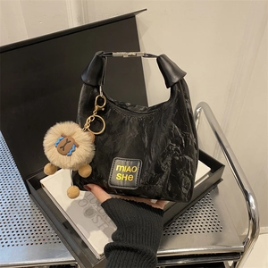 Minimalist black pleated handbag with MIAO SHE logo and cute plush sheep pendant