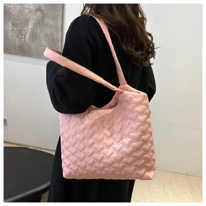Detail der rosa gesteppten Tragetasche mit Herzmuster, Textur und gepolstertem Gurt