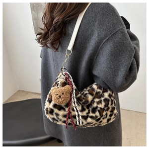 Détail du cabas en peluche léopard avec bandoulière blanche et breloque petit ours