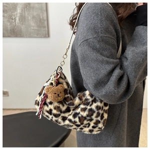 Détail d'un sac cabas en peluche léopard avec breloque ours et ruban à carreaux