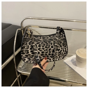 Close-up of leopard print shoulder bag with gold zipper and stylish urban props