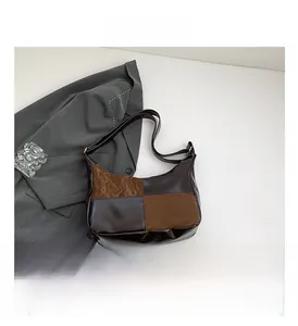Detail view of the vintage contrast-color handbag with smooth PU leather texture