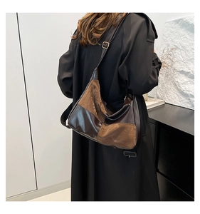Back side view of a bicolor leather tote bag with adjustable strap and gold buckle