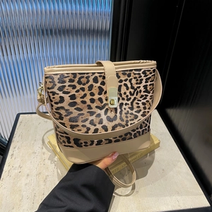 Chic leopard print bucket bag with gold hardware and beige strap for stylish women