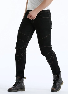 Detail of slim-fit black motorcycle jeans with ribbed knee panels and yellow stitching