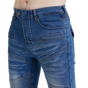 Detail of slim-fit blue motorcycle jeans showing accordion panels and metal button waist