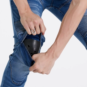 Detail showing the insertion of black protective knee pads into blue motorcycling jeans