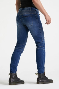 Detail van de geribbelde knie-stiksels in motostijl en MOTO Jeans-borduurwerk op blauwe denim