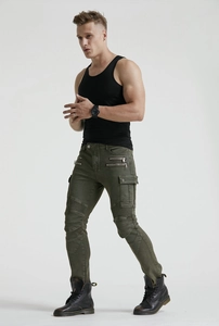 Detail of olive green motorcycle jeans showing decorative zippers and pleated knee panels