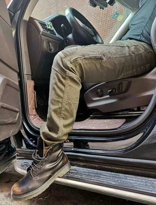 Détail du pantalon de moto tactique vert armée avec plis aux genoux et bottes noires