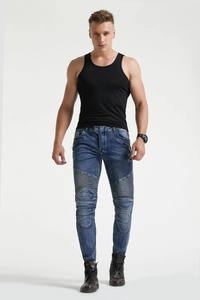 Close-up of blue denim biker pants with pleated knee panels and decorative zip pockets