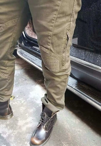 Détail du pantalon cargo de moto vert armée avec plis aux genoux et poches tactiques zippées