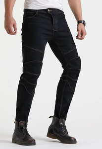 Detail van zwarte motorjeans met moto-ribbels en contrasterende oranje stiksels