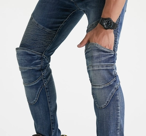 Detail showing the pleated accordion stretch panels and washed texture on biker jeans
