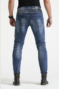 Detail of accordion stretch panels and leather logo on retro slim biker motorcycle jeans